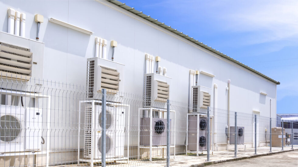 Bank of commercial refrigeration condensing units outside a store
